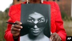 Sharon Napoleon holds a program as she stands outside a viewing for legendary singer Aretha Franklin at New Bethel Baptist Church, Aug. 30, 2018, in Detroit. Franklin died Aug. 16, 2018, of pancreatic cancer at age 76.