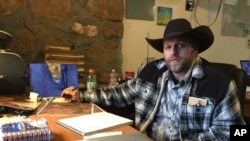 FILE - Ammon Bundy sits at a desk he's using at the Malheur National Wildlife Refuge in Oregon, Jan. 22, 2016. The jailed leader of an armed group that took over an Oregon wildlife preserve struck a defiant tone Tuesday while again urging four holdouts to leave.
