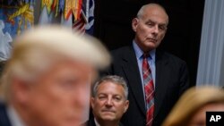 White House chief of staff John Kelly listens as President Donald Trump speaks during a meeting on tax policy with business leaders in the Roosevelt Room of the White House, Oct. 31, 2017.
