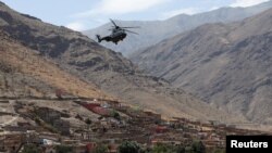 A view shows a helicopter flying over the devastated village of Adassil