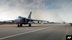 In this photo taken from Russian Defense Ministry official website on Oct. 6, 2015, a Russian SU-24M jet fighter prepares to take off from an airbase Hmeimim in Syria. 