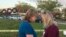 Beverly Turner and Michele Brown huddle to pray in front of a fence decorated with wreaths as students and faculty arrive at Marjory Stoneman Douglas High School for the first time since the mass shooting in Parkland, Florida, Feb. 28, 2018. 