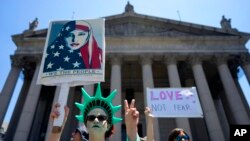 Counter demonstrators opposing a group who gathered across the street to protest against Islamic law, hold signs, June 10, 2017, in New York. In more than two dozen cities across the United States, the group organizing the rallies, ACT for America, is spe