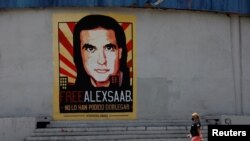 Una mujer camina junto a un mural en apoyo a la liberación del empresario y enviado colombiano Alex Saab, quien se encuentra detenido en Cabo Verde por cargos de lavado de dinero, en Caracas. Septiembre 9, 2021.