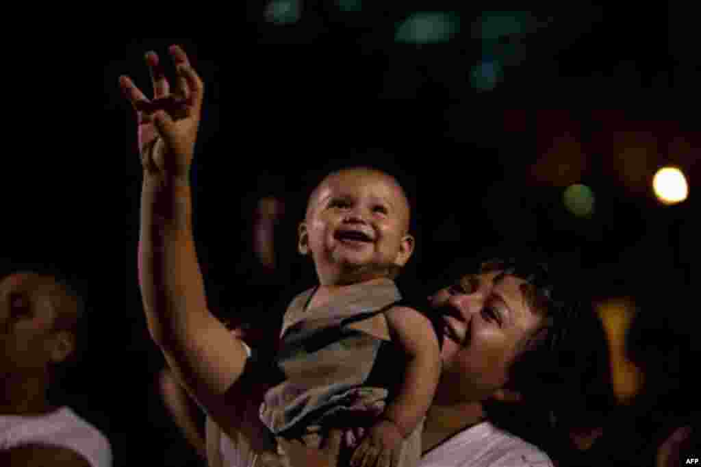 Spectators watch the annual Independence Day fireworks over the Hudson River, Monday, July 4, 2011, in New York. A portion Manhattan's west side is closed to vehicular traffic, allowing pedestrians to camp out and wait for the 40,000 shells launched after