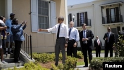 Obama felaketten sonra yeni konutlara yerleştirilen New Orleanslılarla. 