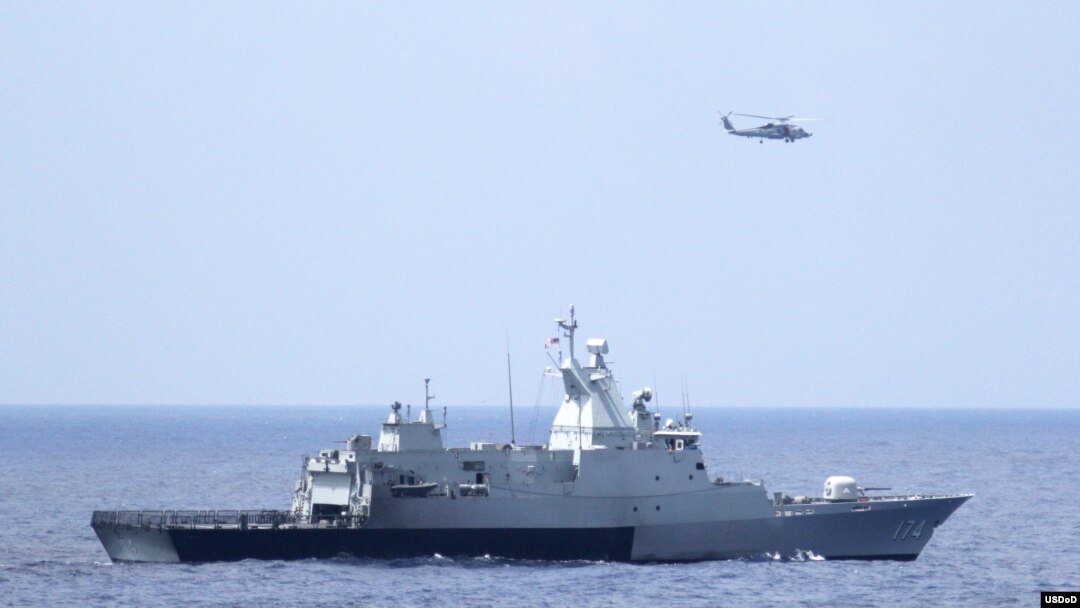 3月12日美国海军直升机与马来西亚海军配合搜寻失踪的马航370班机（图片由美国海军提供）