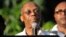 Former Haitian President Jean Bertrand Aristide speaks to supporters at the entrance to his home in Port-au-Prince, after giving a speech for the opening ceremony of the Lavalas Political Party, Sept. 30, 2015.