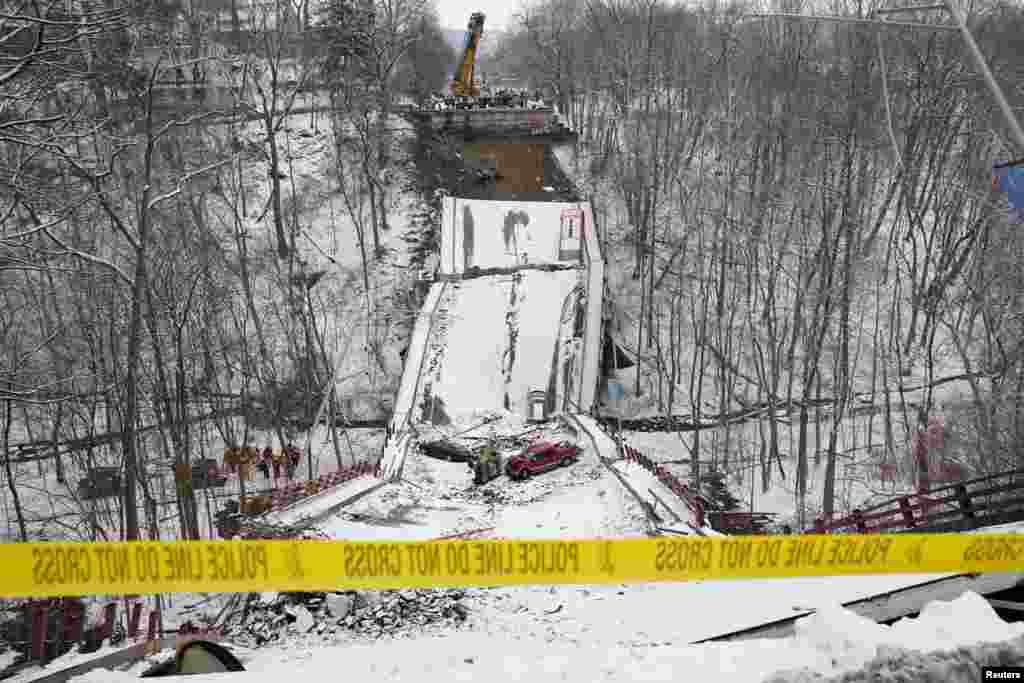 Vehicles are seen on the remains of a bridge that collapsed ahead of a visit by U.S. President Joe Biden in Pittsburgh, Pennsylvania.