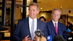 Senator Jeff Flake berbicara kepada para wartawan didampingi Eric Schmidt (belakang), mantan Kepala Eksekutif Google di Havana, Kuba, Senin, 4 Juni 2018.