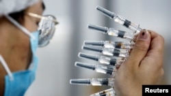 FILE - A worker performs a quality check at Chinese vaccine maker Sinovac Biotech in Beijing on Sept. 24, 2020. The United States on Jan. 15, 2025, announced new export controls on some biotechnology equipment, saying China could put it to military use.