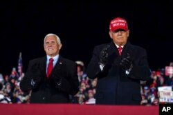 President Donald Trump arrives for a campaign rally at Gerald R. Ford International Airport, Nov. 2, 2020, in Grand Rapids, Mich., with Vice President Mike Pence.