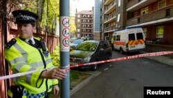 A police officer guards a block of flats in Greenwich following a raid in connection with the killing of a British soldier in nearby Woolwich, southeast London, May 23, 2013.