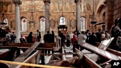 FILE - In this Sunday, Dec. 11, 2016, file photo, security forces examine the scene inside the St. Mark Cathedral in central Cairo, following a bombing.