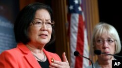 Sen. Mazie Hirono, D-Hawaii, left, holds back tears as she recalls images of drowned migrants, during a news conference on new legislation regarding detention of immigrants near the southern border, July 11, 2019, on Capitol Hill in Washington.