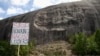 A protest sign is held up in front of the Confederate Monument carved into granite at Stone Mountain Park in Stone Mountain, Georgia, June 16, 2020.