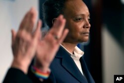 La alcaldesa de Chicago, Lori Lightfoot, hace una pausa durante su discurso de concesión mientras su esposa, Amy Eshleman, aplaude durante una fiesta de la noche de las elecciones para la elección de alcalde el martes 28 de febrero de 2023 en Chicago. (Foto AP/Charles Rex Arbogast)