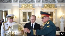 Presiden Rusia Vladimir Putin (tengah), Menteri Pertahanan Sergei Shoigu, (kanan) dan Panglima Angkatan Laut Rusia Laksamana Vladimir Korolev dalam perayaan Hari Angkatan Laut Rusia. (Foto:dok)