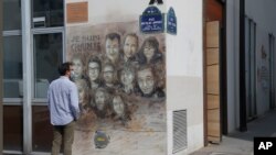 A man looks at a painting by French street artist Christian Guemy, aka "C215," in Paris, France, Sept. 2, 2020, in tribute to the members of the satirical newspaper Charlie Hebdo attacked by jihadist gunmen in January 2015.
