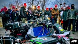 Para pendukung Presiden Donald Trump berdiri dekat sejumlah peralatan yang mereka rusak dalam unjuk rasa di luar Gedung Kongres AS, di Washington DC, 6 Januari 2021. (Foto: AFP)