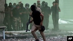 Iraqi security forces try to disperse anti-government protesters during ongoing protests in downtown Baghdad, Iraq, Sunday, Nov. 10, 2019. (AP Photo/Hadi Mizban)