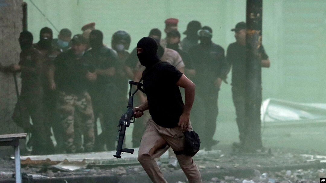 Iraqi security forces try to disperse anti-government protesters during ongoing protests in downtown Baghdad, Iraq, Sunday, Nov. 10, 2019.