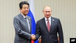 PM Jepang Shinzo Abe (kiri) dan Presiden Rusia Vladimir Putin dalam pertemuan di sela KTT APEC di Lima, Peru, 20 November lalu (foto: dok). 