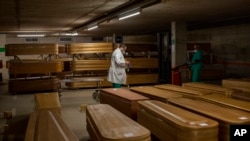 Coffins with the bodies of victims of coronavirus are stored waiting for burial or cremation at the Collserola morgue in Barcelona, Spain, Thursday, April 2, 2020. The new coronavirus causes mild or moderate symptoms for most people, but for some,…