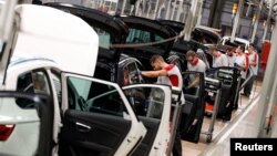 Workers assemble vehicles on the assembly line of the SEAT car factory in Martorell, near Barcelona, Spain, Oct. 31, 2018.