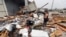 Jennifer Bryant looks over the debris from her family business destroyed by Hurricane Harvey, in Katy, Texas, Aug. 26, 2017.