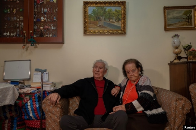 Ioanna Matsouka, 93, and her husband Kostas Matsoukas pose for a picture in their house in Athens, Greece, March 6, 2024. (REUTERS/Karolina Tagaris)