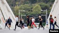 FILE - Women jog on Ponte della Musica during an exercise class, as the spread of the coronavirus disease (COVID-19) continues in Rome, Italy, Nov. 2, 2020. 