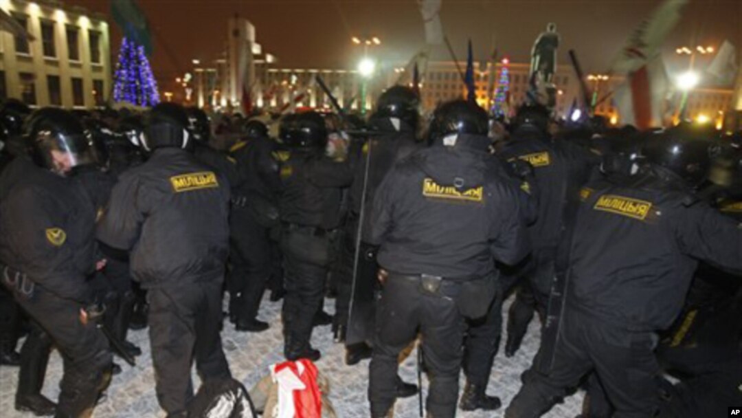 A demonstrator, wrapped in a white-red-white national flag, banned under authoritarian president Alexander Lukasheno, lies on the ground in the Belarusian capital, Minsk, Sunday, Dec. 19, 2010.