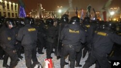 A demonstrator, wrapped in a white-red-white national flag, banned under authoritarian president Alexander Lukasheno, lies on the ground in the Belarusian capital, Minsk, Sunday, Dec. 19, 2010.