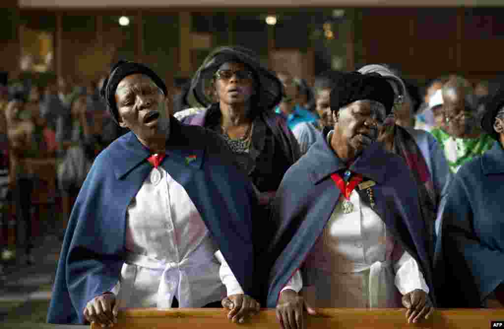 Women sing during a mass commemorating the late South African former President Nelson Mandela in Soweto, near Johannesburg. 
