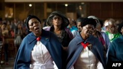 Des femmes chantent lors d'une messe à la mémoire l'ancien président sud-africain Nelson Mandela, le 8 décembre 2013, à Soweto, près de Johannesburg.