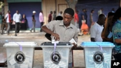 A Tanzanian man casts his vote in the presidential election at a polling station in Dar es Salaam, Tanzania Sunday, Oct. 25, 2015.