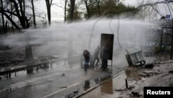 Greek riot police use a water cannon to disperse migrants on the no man's land between Turkey and Greece, at Turkey's Pazarkule border crossing with Greece's Kastanies, in Edirne, Turkey, March 8, 2020.