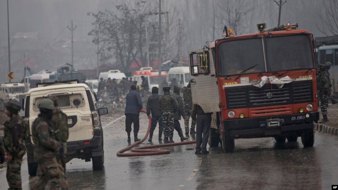 Seorang petugas pemadam kebakaran India menyemprotkan air di jalan untuk membersihkan bekas darah setelah ledakan di Pampore, Kashmir yang dikuasai India, 14 Februari 2019.