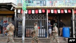 15일 남아프리카공화국 요하네스버그에 배치된 군인들이 상점 앞을 지나고 있다. 