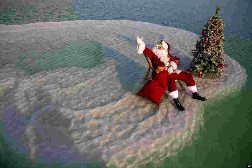 یک مرد در اسرائیل در لباس بابانوئل در دریای مرده یا بحرالمیت. کم کم کشورها برای برگزاری مراسم آخر سال میلادی آماده می‌شوند. 