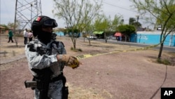 ARCHIVO - Una Guardia Nacional acordona un área donde una persona fue asesinada dentro de un autobús en Celaya, México, el 29 de febrero de 2024.