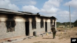 A member of Kenya’s security forces walks past a damaged police post after an attack by al-Shabab extremists in the settlement of Kamuthe, in Garissa county, Kenya, Monday, Jan. 13, 2020. 