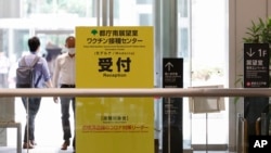 Papan nama kampanye vaksinasi virus corona di gedung Pemerintah Metropolitan Tokyo di Tokyo, Jumat, 25 Juni 2021. (Rodrigo Reyes Marin/Pool Photo via AP)