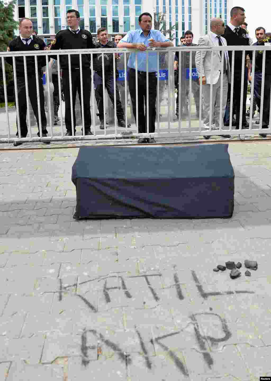 Security guards stand next to a mock coffin left by protesters demonstrating to blame the ruling AK Party (AKP) government on mining disaster in western Turkey, in Ankara May 14, 2014. Rescuers pulled more dead and injured from a coal mine in western Turk