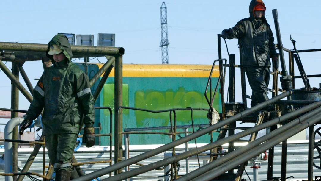 FILE - Oil workers prepare to pump water into the Priobskoye oil field in Western Siberia, which once belonged to the Yukos oil company and were bought by state oil company Rosneft, after a controversial auction in 2004.