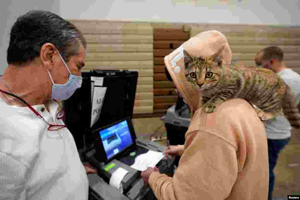 Barton Foley, 32, with his cat &quot;Little Ti Ti&quot; on his shoulder, casts his ballot on Election Day at Ballard High School in Louisville, Kentucky, Nov. 3, 2020. 