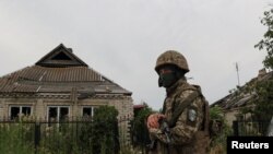 Un militar ucraniano camina junto a una casa dañada por ataques militares rusos en la aldea de Vremivka, en medio del ataque de Rusia a Ucrania, cerca de una línea de frente en la región de Donetsk, Ucrania, el 8 de julio de 2023.