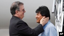 Mexican Foreign Minister Marcelo Ebrard, left, welcomes former Bolivian President Evo Morales upon his arrival to Mexico City, Tuesday, Nov. 12, 2019. 