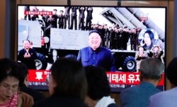 People watch a TV showing a file image of North Korean leader Kim Jong Un during a news program at the Seoul Railway Station in Seoul, South Korea, Oct. 2, 2019.